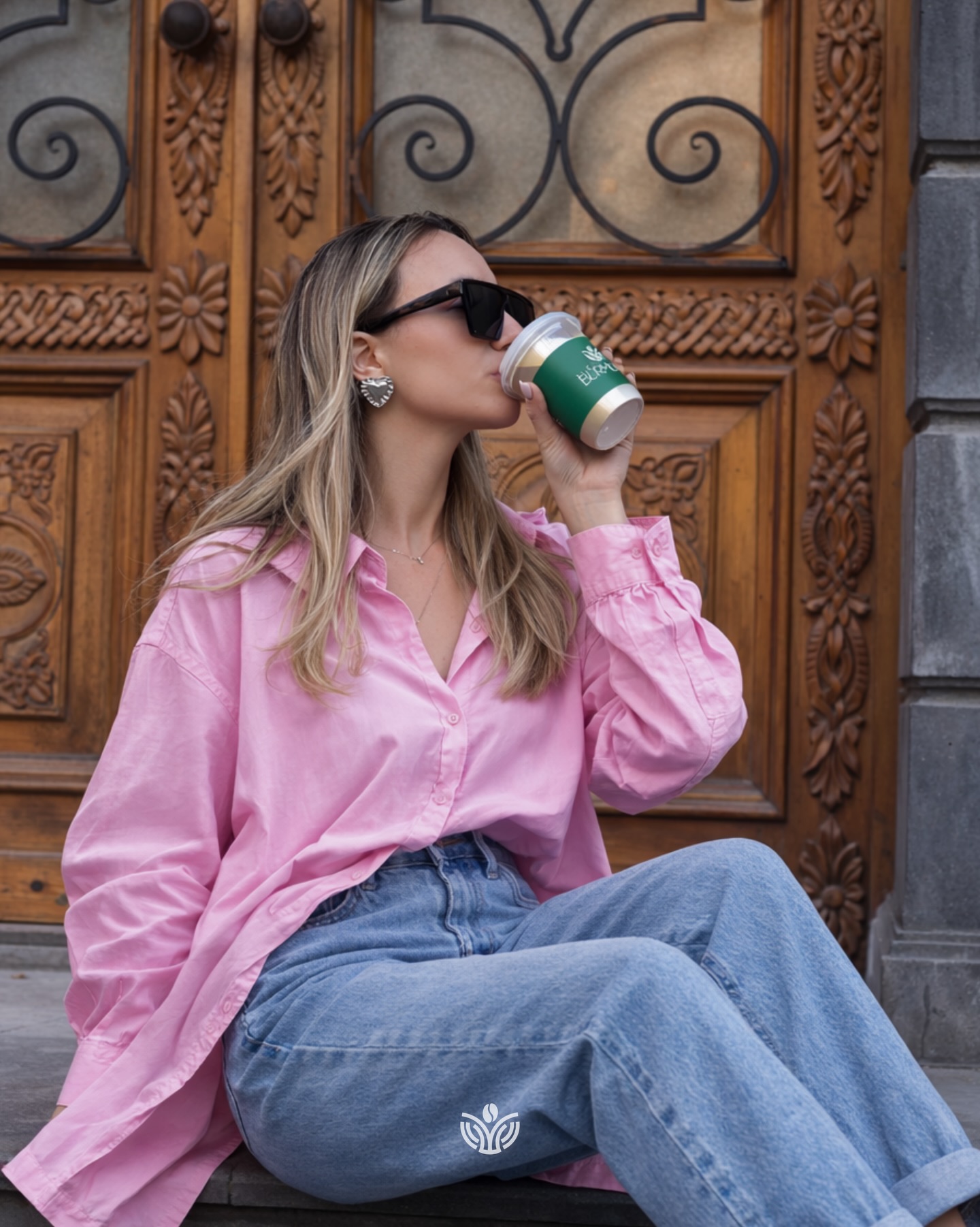 Woman drinking Coffee Burmunq from a takeaway cup